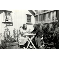 003006 - Två kvinnor vid ett trädgårdsbord.