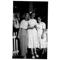 000989 - Tre kvinnor står vid ett staket