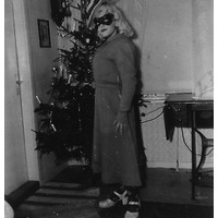 002309 - En person utklädd framför julgran