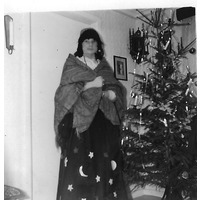 002310 - En person utklädd framför julgran