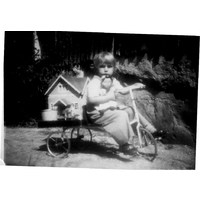 000541 - Flicka på trehjuling. Hon håller en docka i sin famn