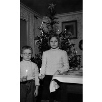 002055 - Barn med tända ljus vid julgran.