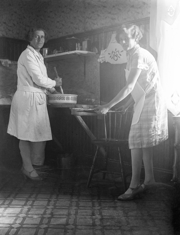 Två okända kvinnor som bakar.
