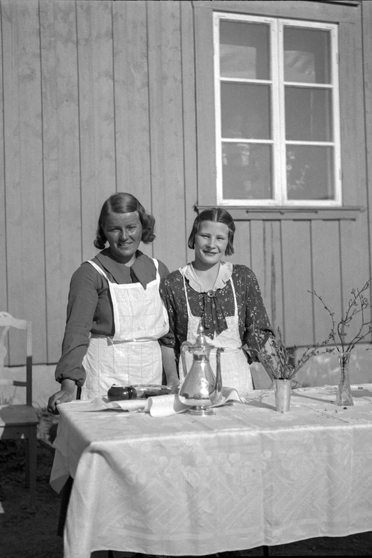 Två unga kvinnor vid serveringsbord.