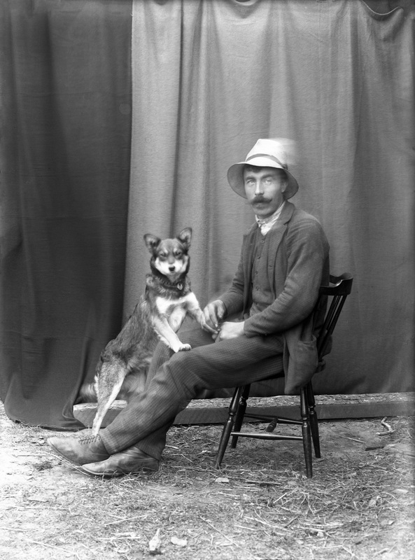 Porträtt på en okänd karl och en hund.