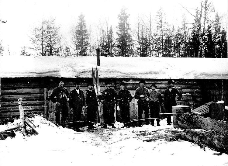 En grupp män framför en timmerkoja.