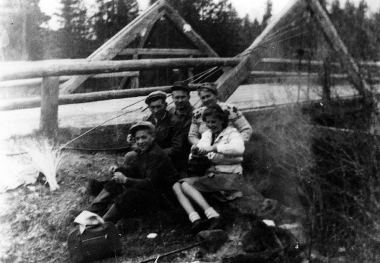 Grupp framför landsvägsbro av trä.