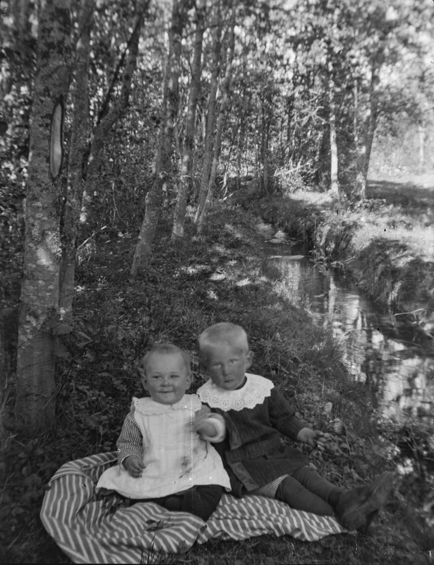 Två små barn vid en å, ej identifierad.