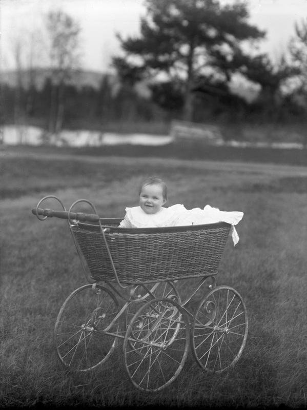 Porträtt på ett barn i barnvagn.