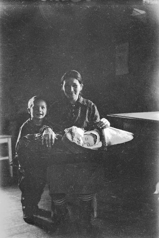 Kvinna och två barn i inomhusmiljö