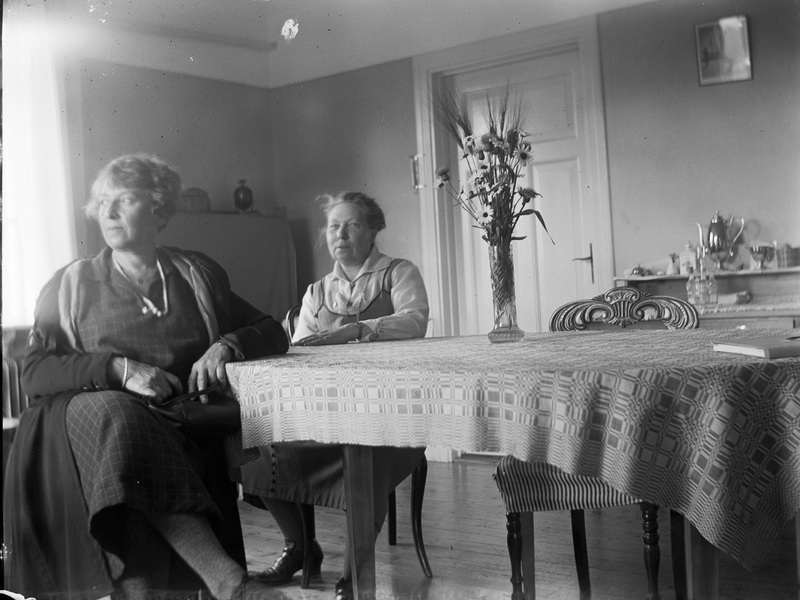 Två okända kvinnor vid ett bord