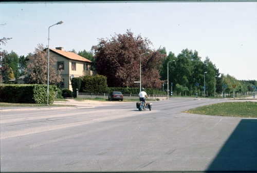 Man åker förbi Folkets hus på moped. 2000-05-11