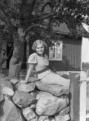 Sonja Nilsson sittande på stengärde Krogshult.
