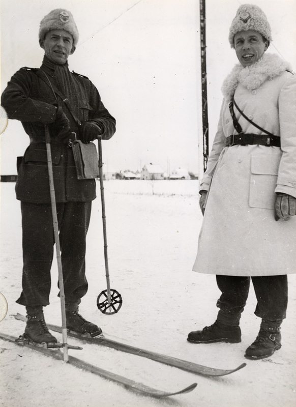 Militärbefäl i vinteruniform, varav en på skido...