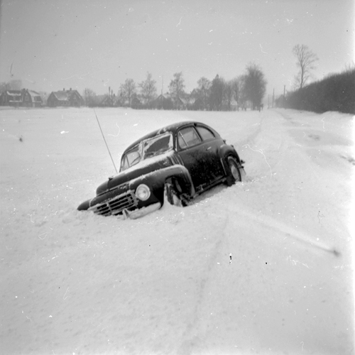 Snömotiv år 1956. Bil som kört av vägen.