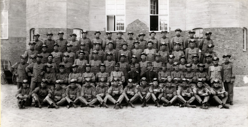 Soldater framför en kasernbyggnad.
