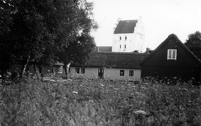 Bondgård. Farhults kyrka i bakgrunden.