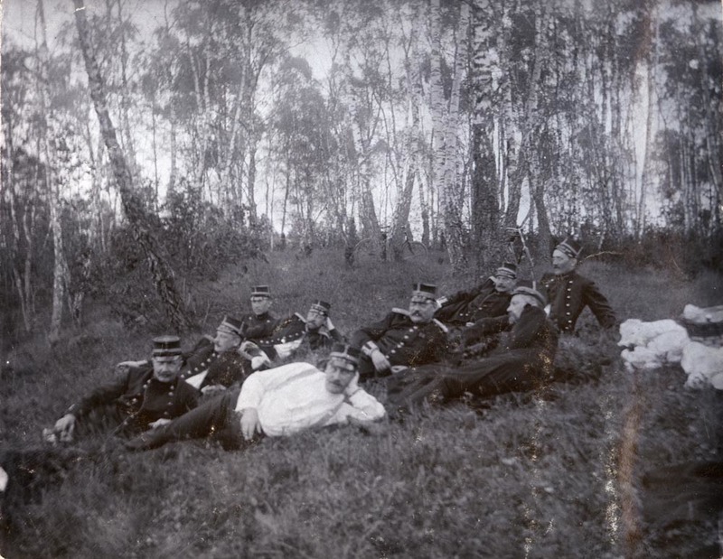 En grupp militärer vilar sig i en björkdunge.