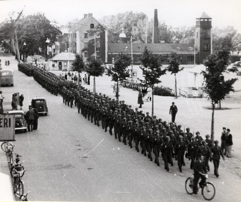Soldater på marsch i stadsmiljö.