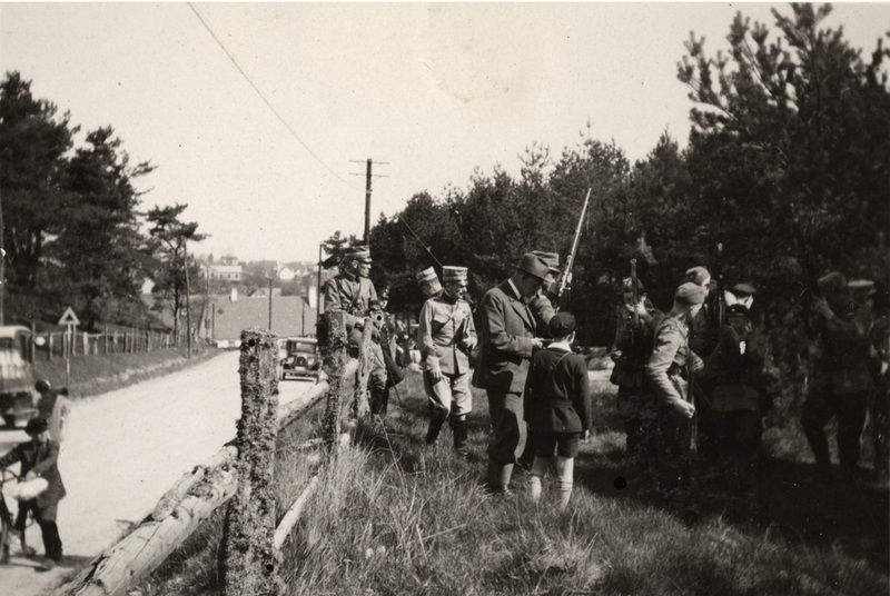 Militärövning i skogsområde invid landsväg.