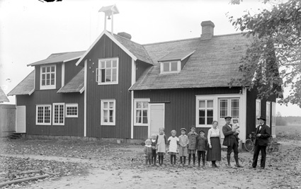 Gruppbild framför hus (8 barn).