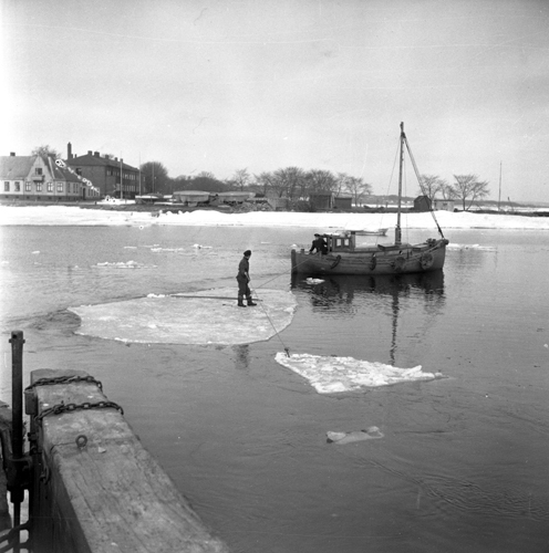 Båtar håller på att röja isen ur hamnen