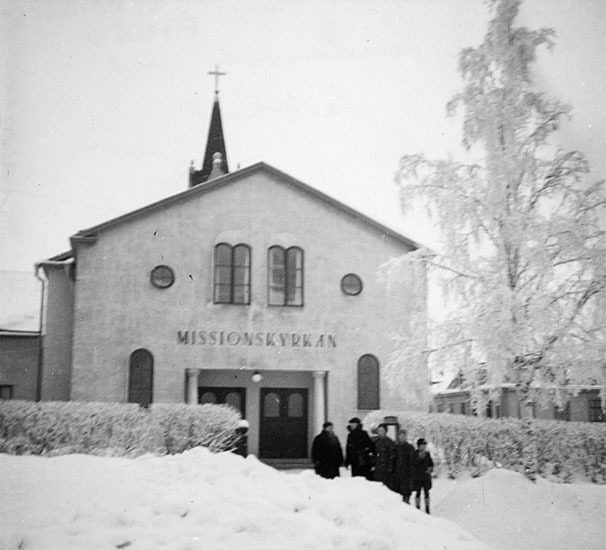 Oskar Lindmark med familj utanför missionskyrka...