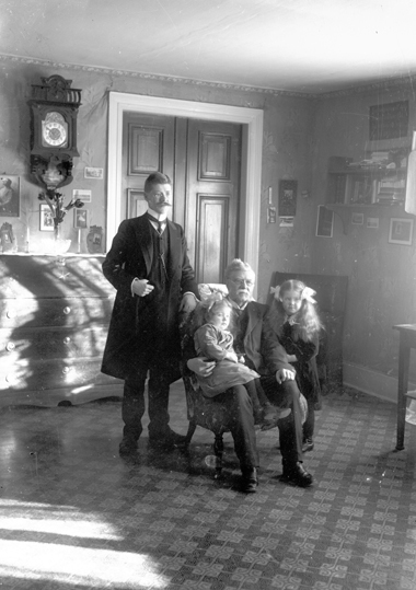 Gruppfoto i hemmiljö med tre generationer.
