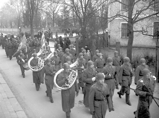 Begravningsfölje med musiker och många militärk...