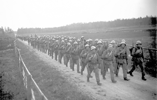 Militärer marscherar på en grusväg kanske på vä...