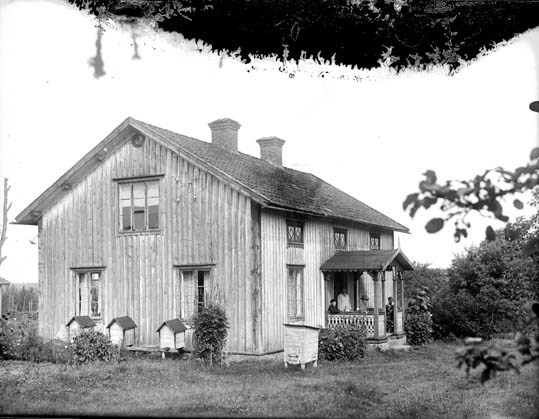 Vi ser ett äldre bostadshus med två våningar, t...