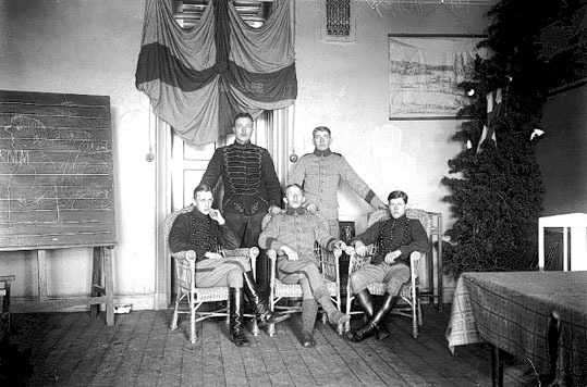 5 julfirande husarer i ett dagrum på regementet...