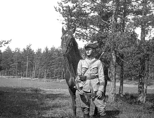 Bilden visar en ensam elev med sin häst, ståend...