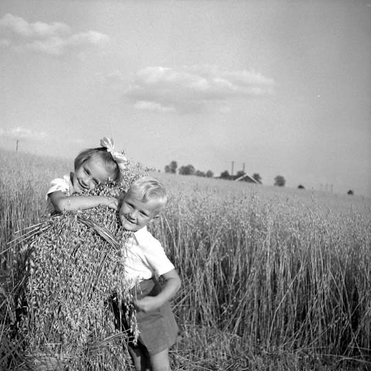 En flicka och en pojke poserar framför fotograf...