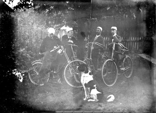 Fyra yngre män med sina cyklar, framför dem sit...