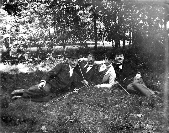 Fyra män som ligger i gröngräset.