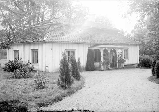 Bilden visar Aneby gård, på verandan som är klä...